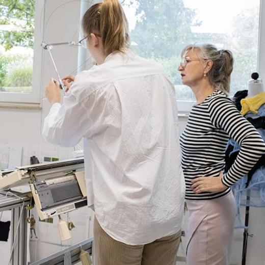 Schülerin und Lehrerin an der Strickmaschine