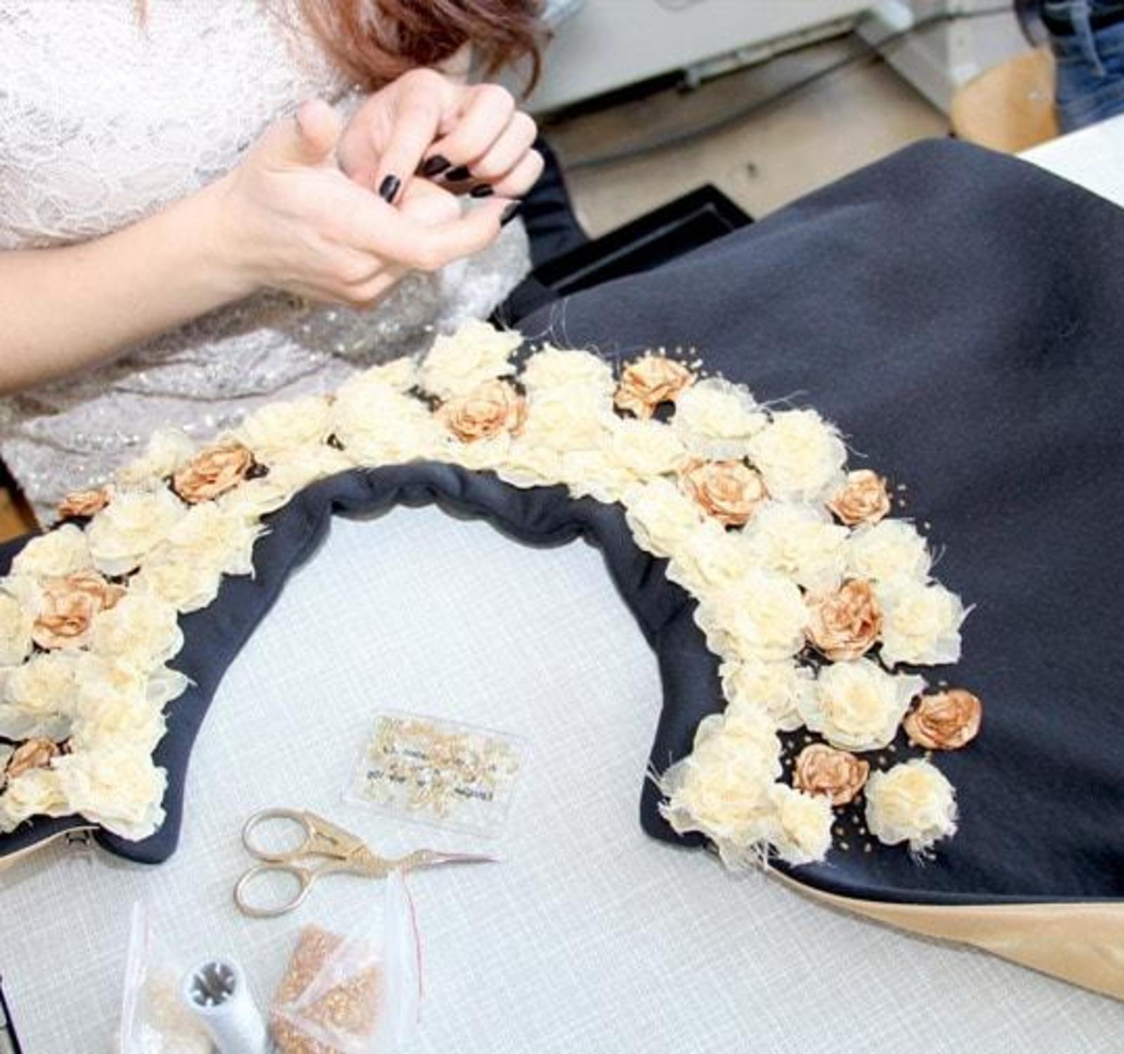 Nahaufnahme einer Handarbeit mit aufgenähten Blumenverzierungen