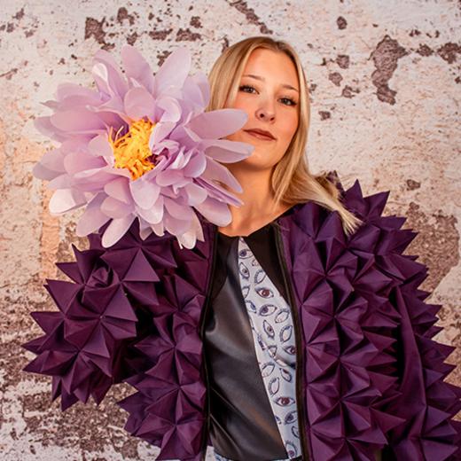 Schülerin mit Papierblume neben dem Gesicht